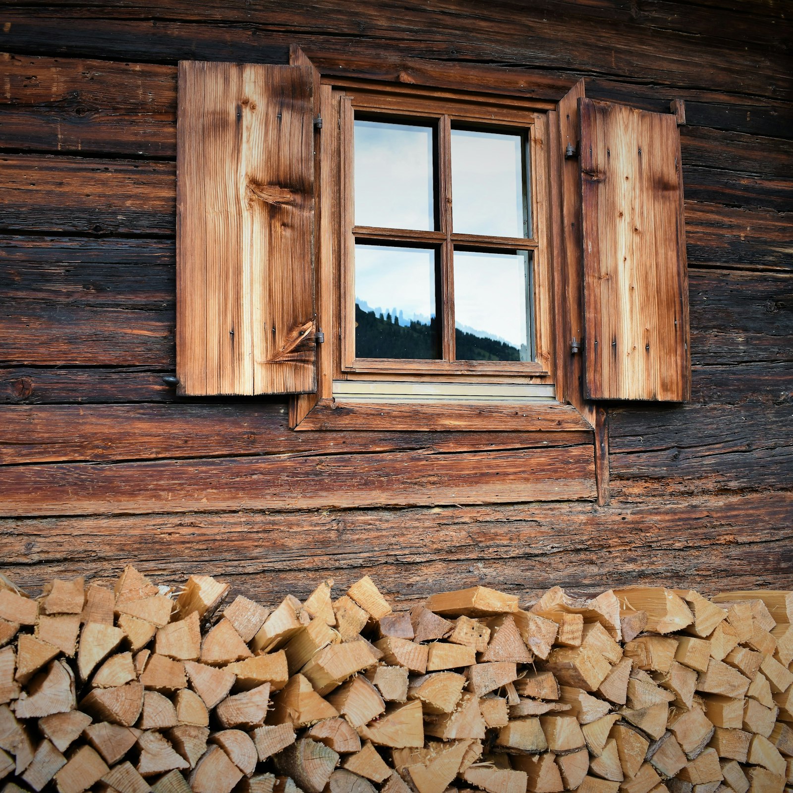 Close view of timber cladding above a stacked firewood wall