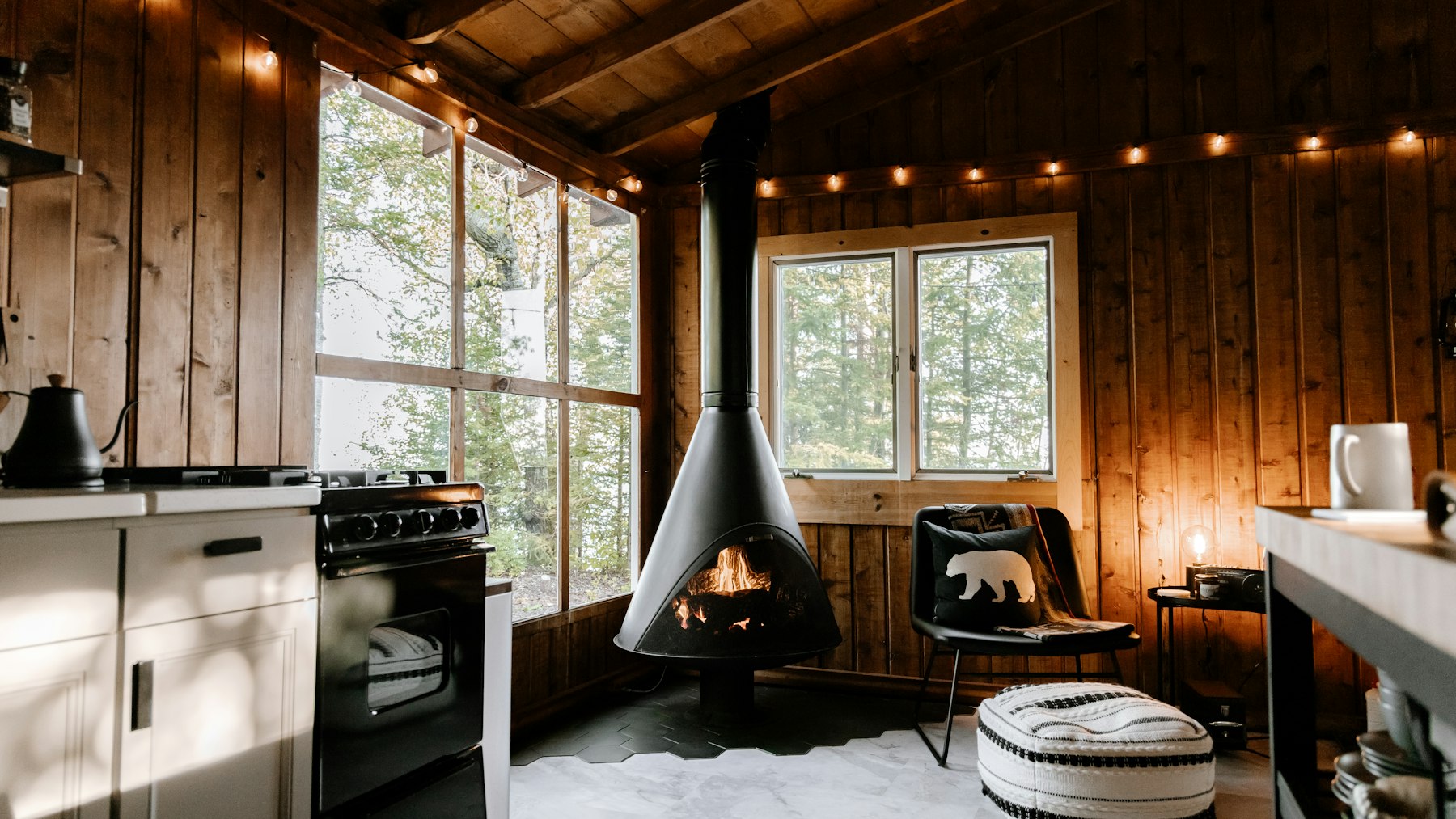 Living room with exposed timber walls and a suspended fireplace