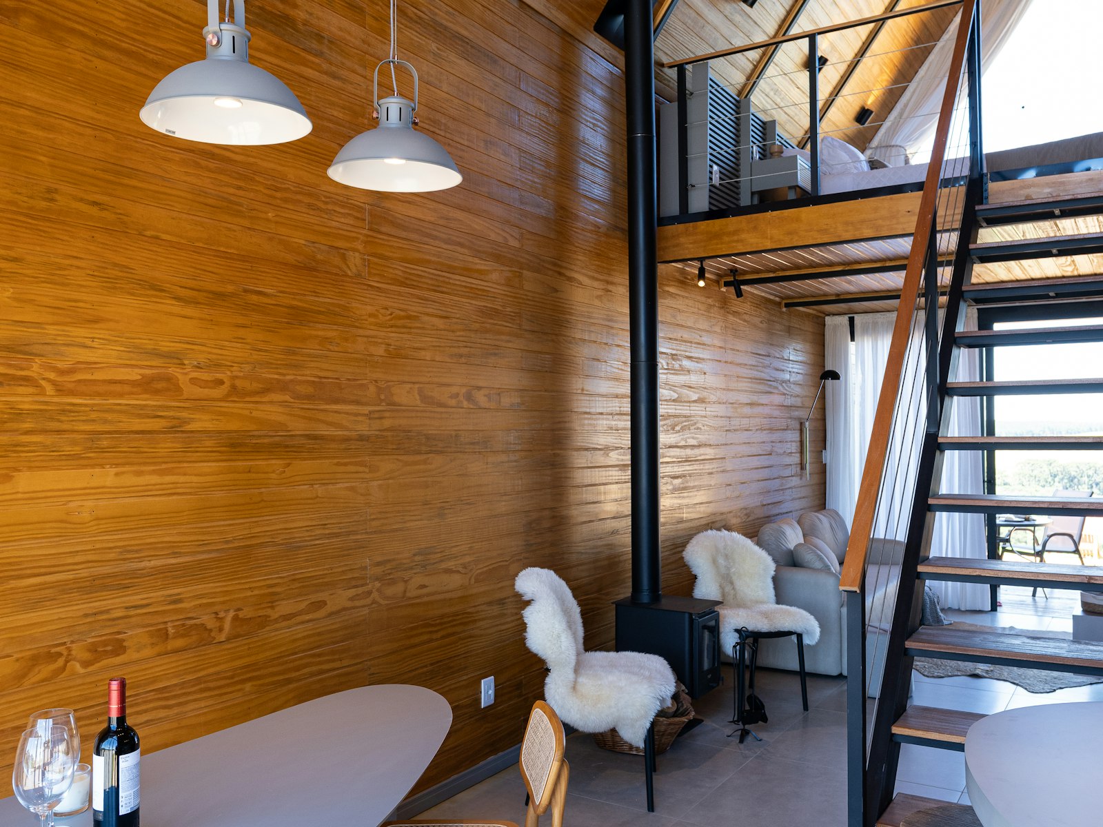Double-height timber living space with a loft stair