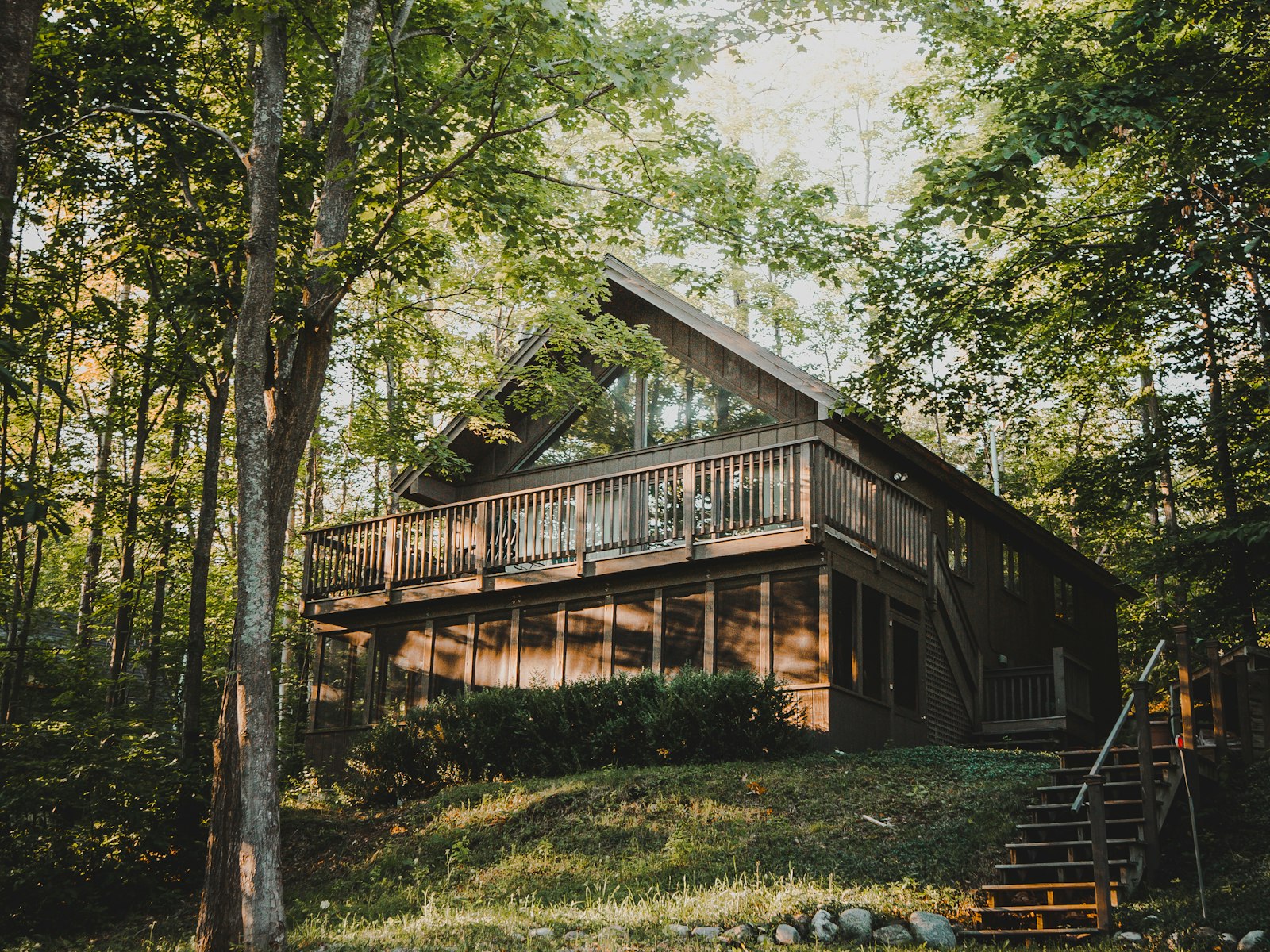 Kras, a timber house with a long covered deck in woodland